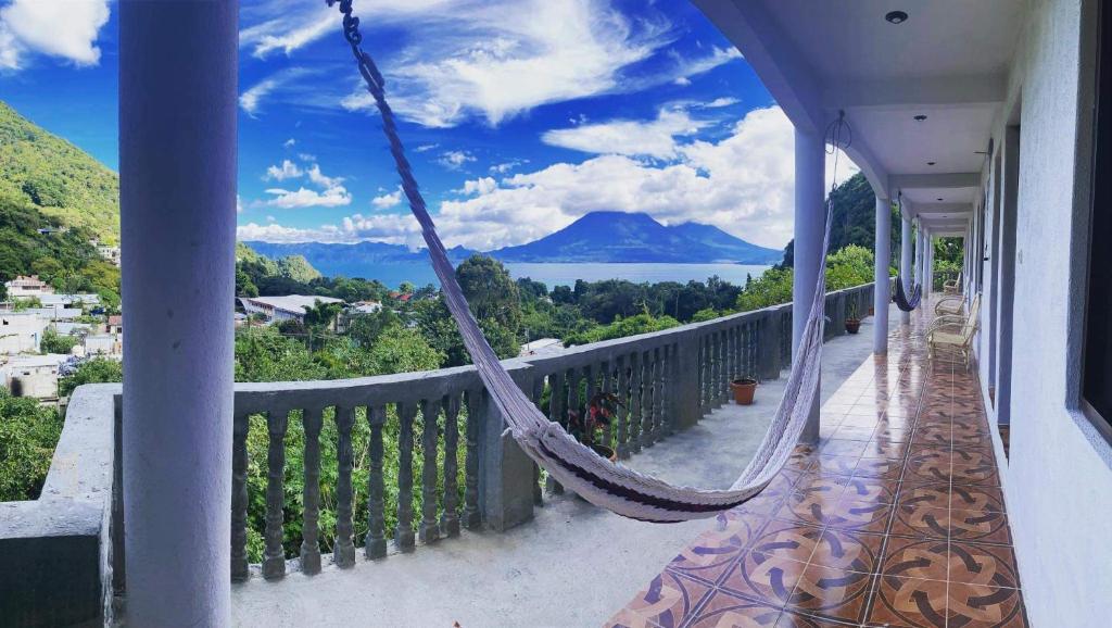 a balcony with a hammock and a view of a mountain at Hotel Berena in San Marcos La Laguna