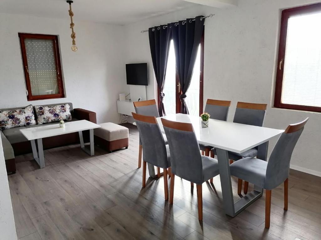 un salon avec une table et des chaises blanches dans l'établissement Villa Apartments STEFAN - Ramne Ohrid, à Ohrid