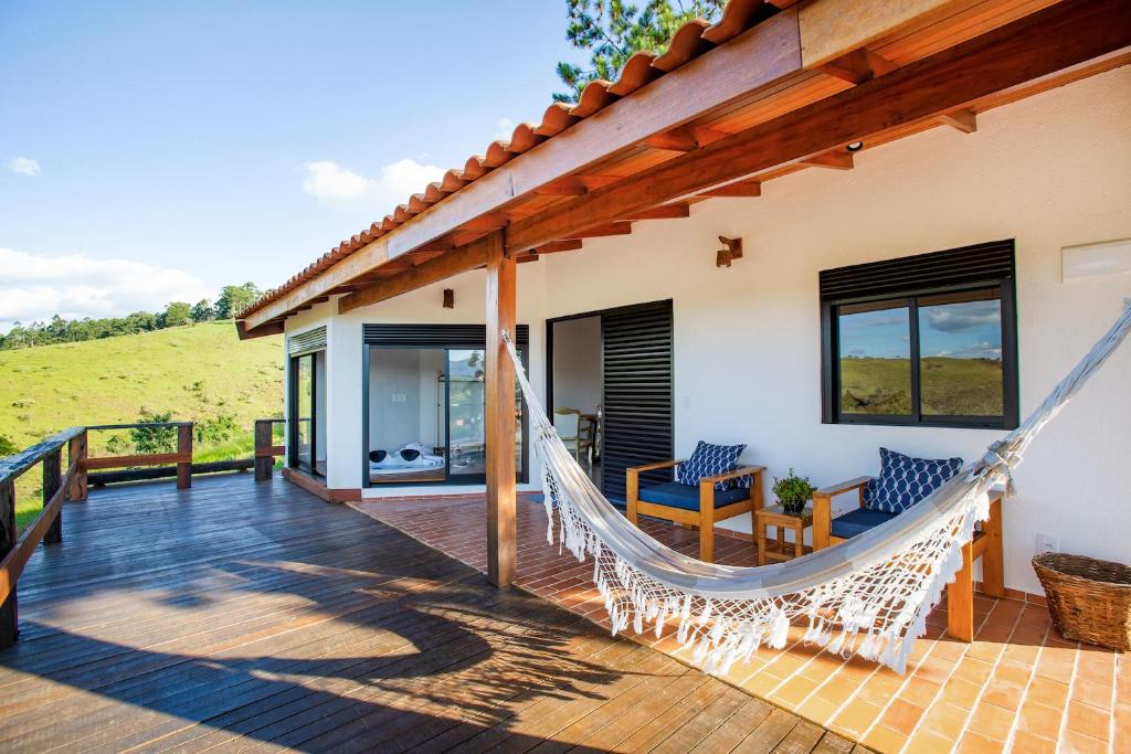 una hamaca en la terraza de una casa en Pousada Lago dos Sonhos en Piracaia