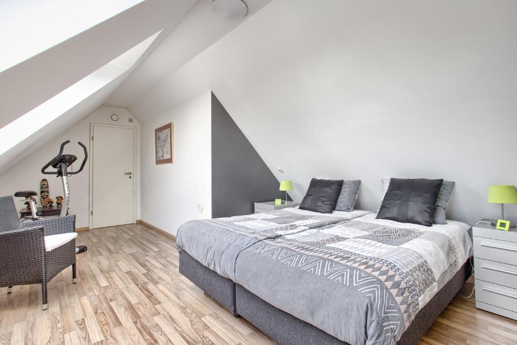 a white bedroom with a bed and a chair at Villa Eltins in Bad Bentheim