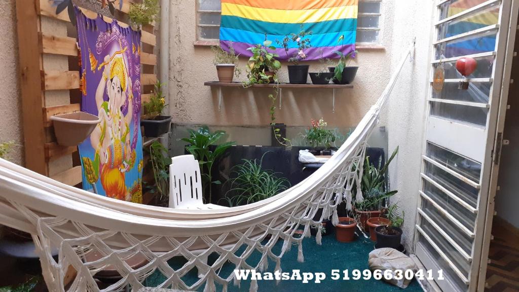 a hammock on the side of a building with plants at Arco Iris Guest House in Porto Alegre