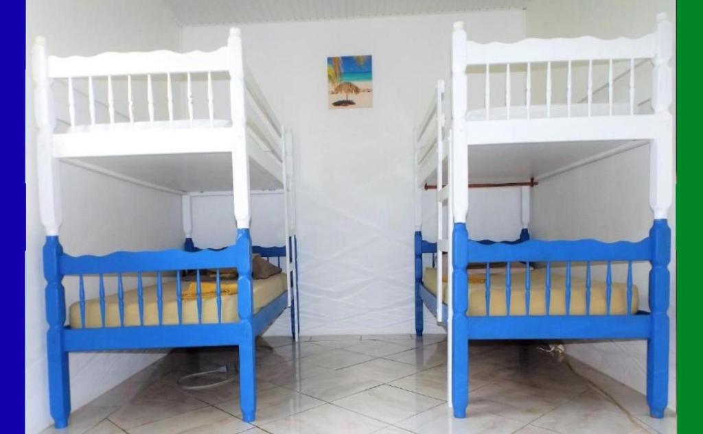 2 letti a castello con letti a castello blu e bianchi in una camera di Hostel des 3 sources a Sainte-Marie