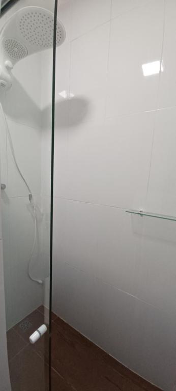 a shower with a glass door in a bathroom at Pousada Neptun in Conde