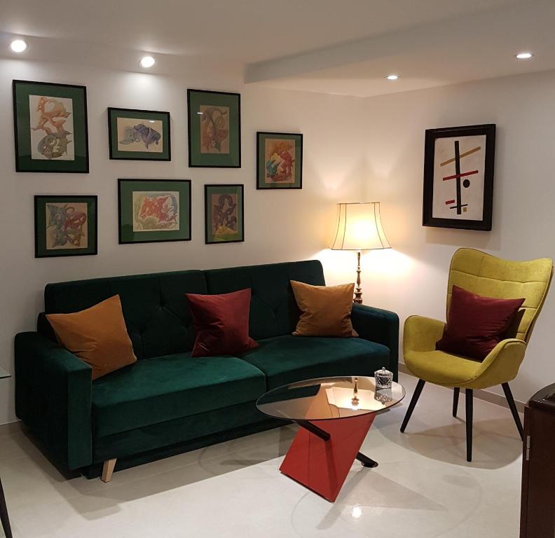 ein Wohnzimmer mit einem grünen Sofa, einem Tisch und Stühlen in der Unterkunft Avantgarde in Euskirchen