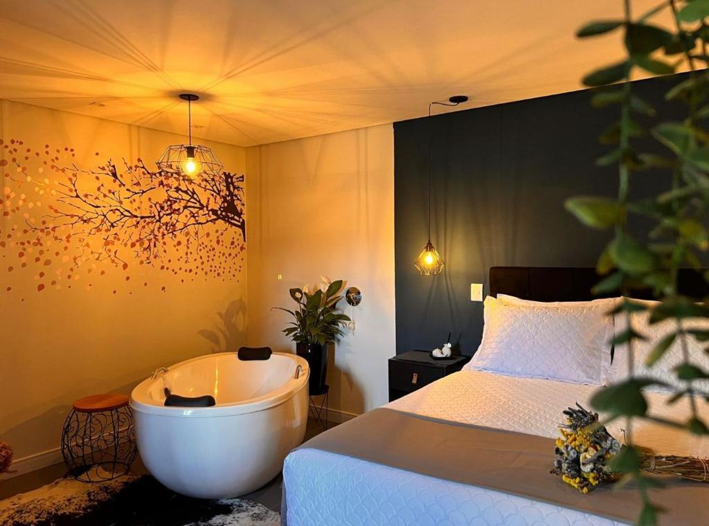 - une chambre avec une baignoire et un lit dans l'établissement Lofts Urbano, à Urubici