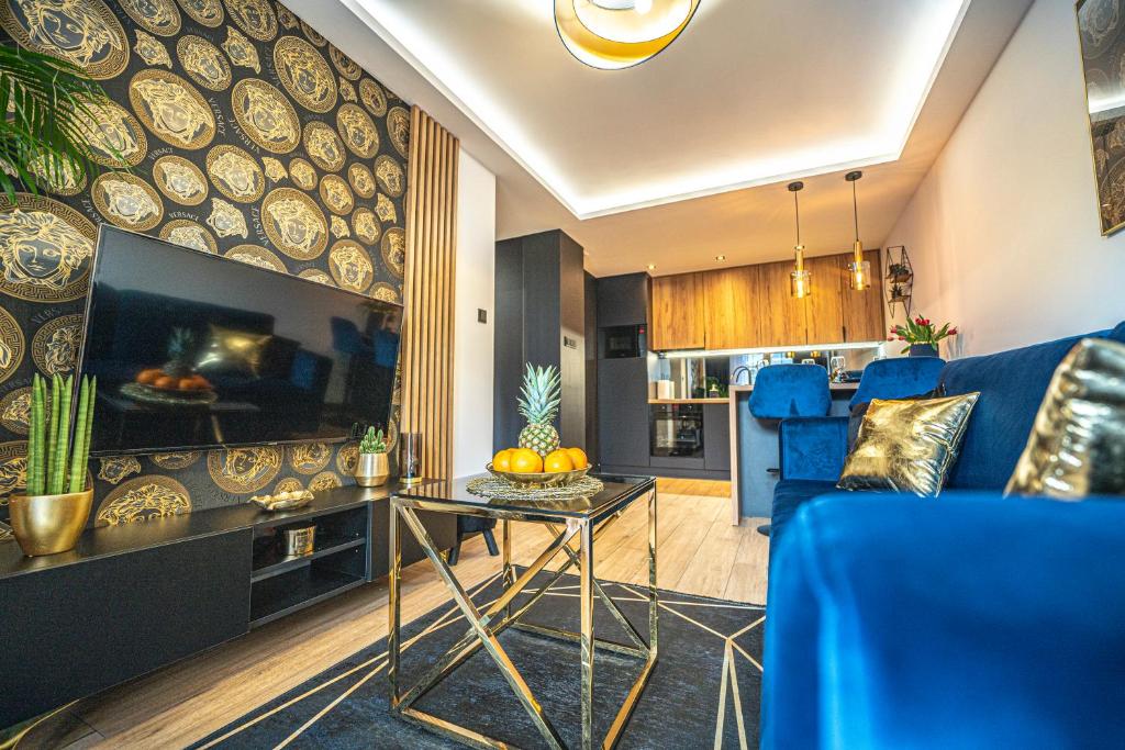 a living room with a blue couch and a table at Apartament Blue Diamond in Karpacz