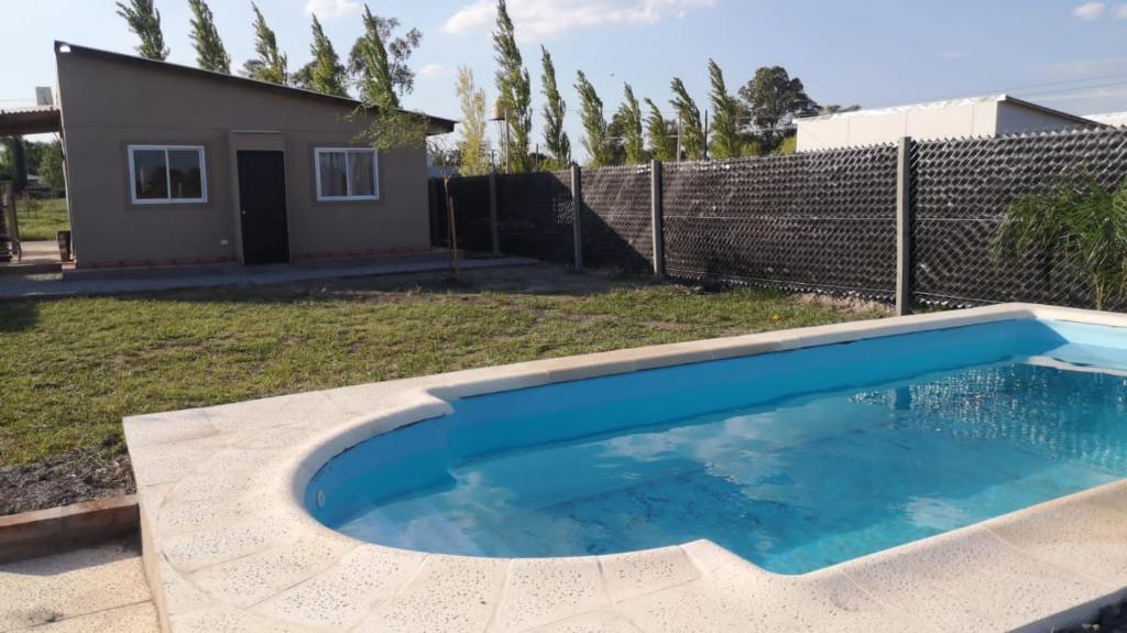 una piscina en un patio con una casa en Cabañas Iñ Püñen en 