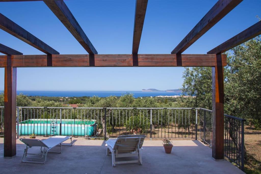 uma vista do deque de uma casa com piscina em Villa Tramonto em Alghero