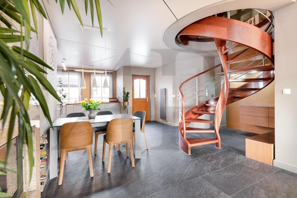 eine Wendeltreppe in einem Esszimmer mit einem Tisch und Stühlen in der Unterkunft Apartament Nadbrzeżna de luxe in Mielno