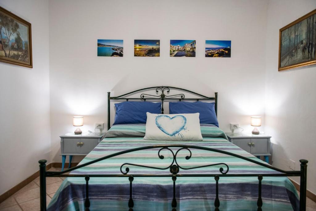 a bedroom with a bed with a heart pillow on it at La casa dei nonni in Paola