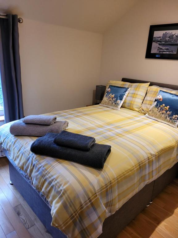 a bedroom with a bed with two towels on it at Orkneyinga in Kirkwall