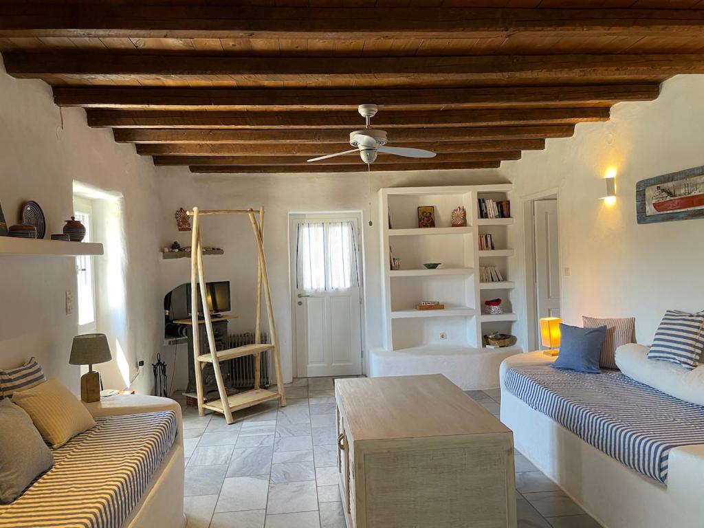 a living room with two beds and a ceiling fan at Villa cycladique POSEIDON in Parikia