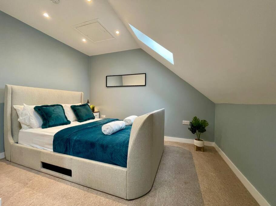 a bedroom with a large bed with a blue blanket at Big Modern House - 15min to NEC - Sleeps 10 in Birmingham