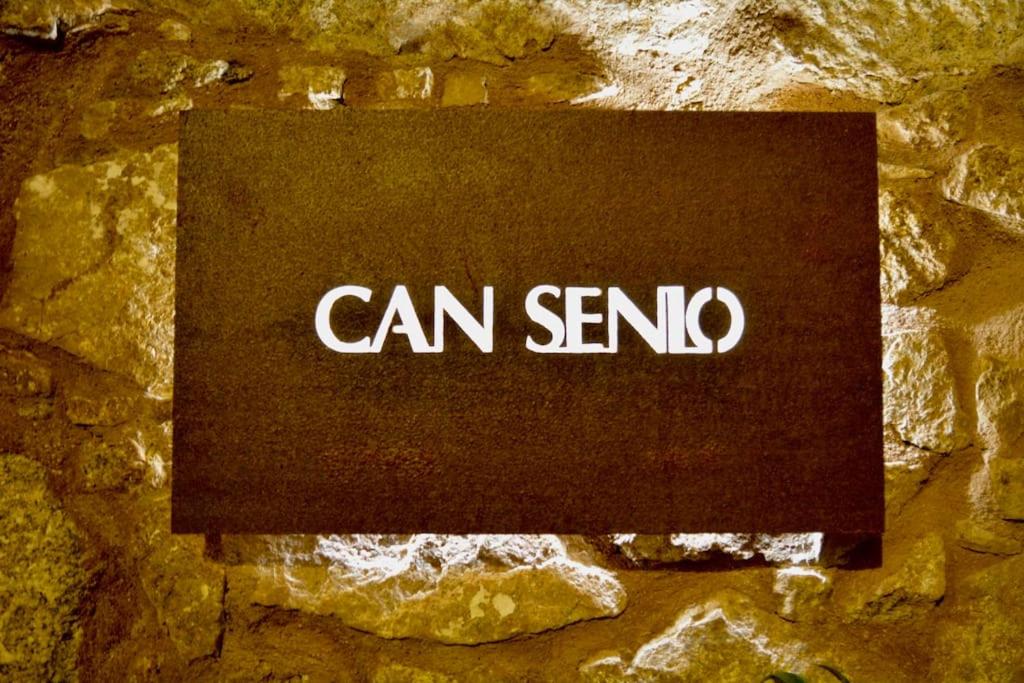 a sign that says can sendo on a stone wall at Can Senio 1 in Tossa de Mar