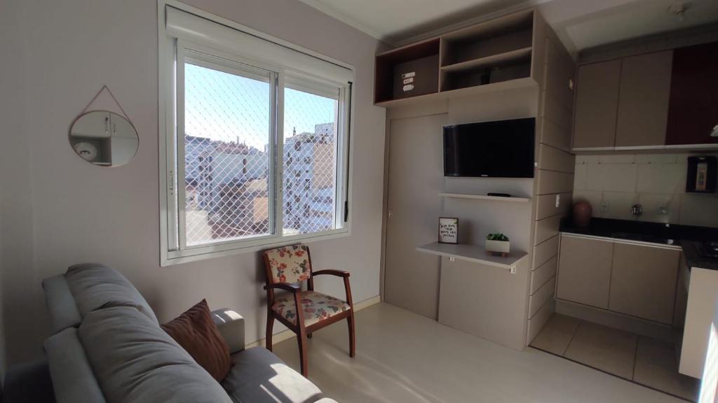 sala de estar con sofá y silla en Cidade Baixa Apart Studio Encantador, en Porto Alegre