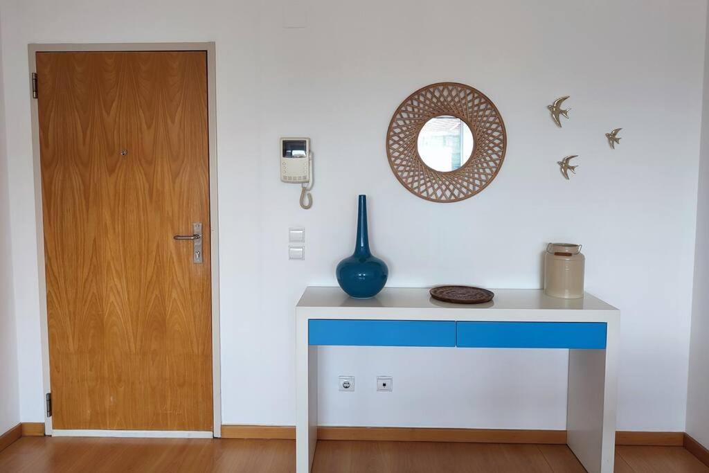 une table bleue et blanche avec un miroir et une porte dans l'établissement Apartment near airport & citycenter Free Parking, à Lisbonne