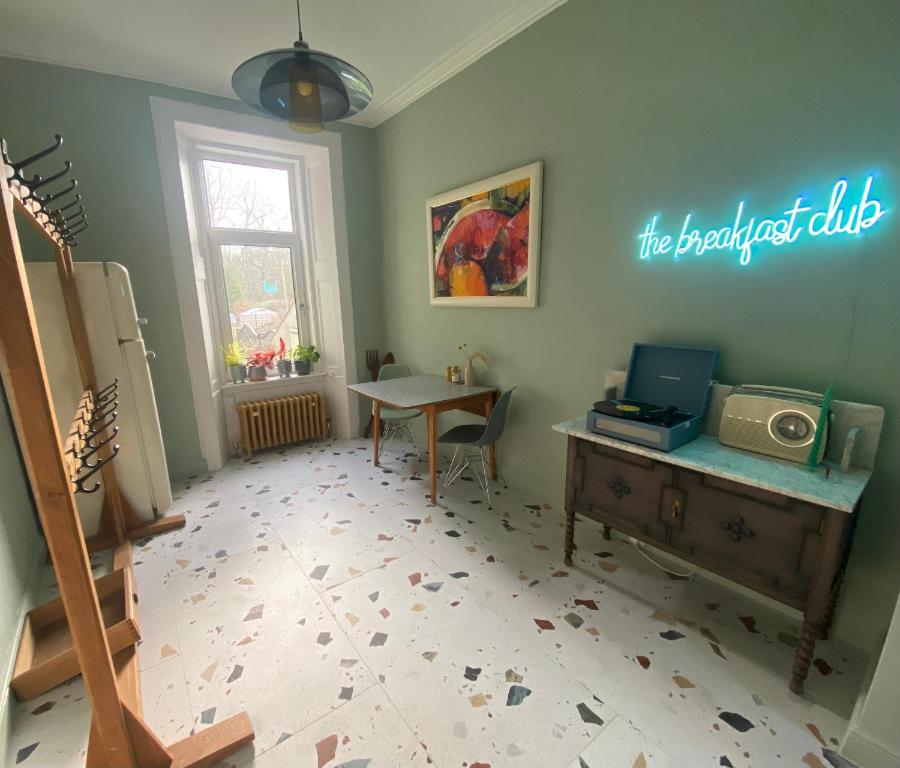 a room with a desk and a table and a sign on the wall at Ben A'an House in Callander