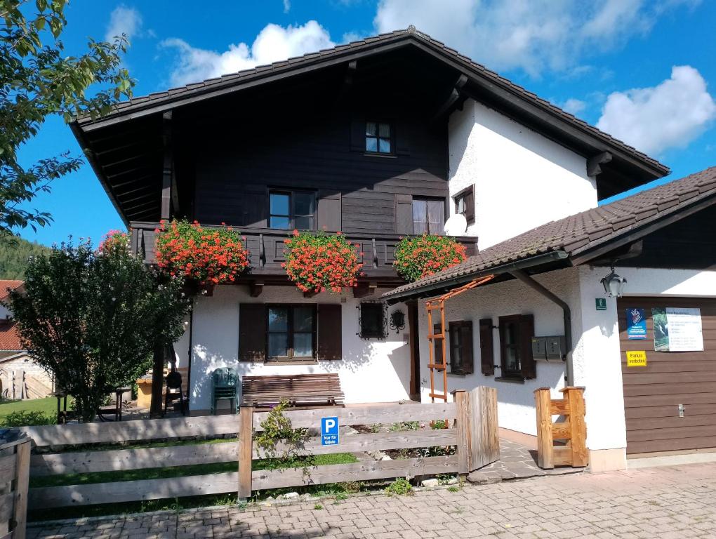 czarno-biały dom z kwiatami na balkonie w obiekcie Gipfelblick am Wössner Bach w mieście Unterwössen