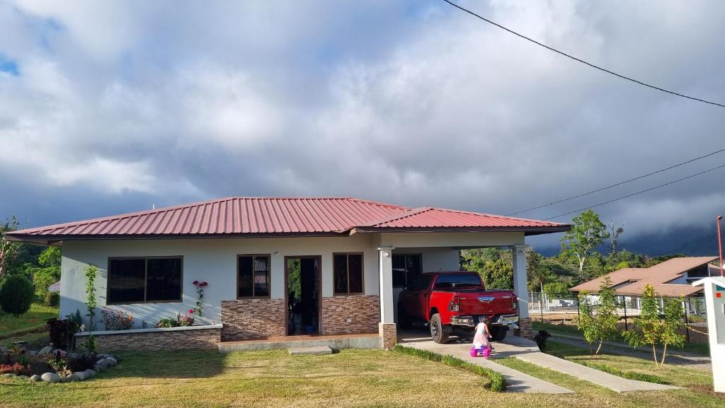 a little girl standing in front of a small house at Vistaverdeboquete in Boquete
