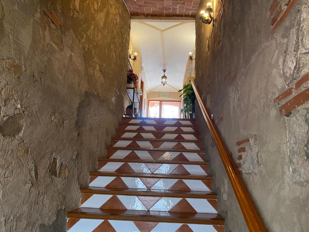 a staircase in a building with a stair case at Hotel Rural Cal Amadeu in Vilanova de Escornalbou