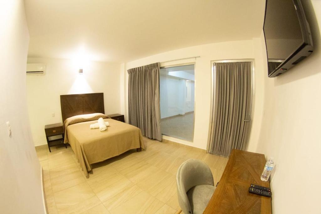 une chambre d'hôtel avec un lit et une télévision dans l'établissement HOTEL REFORMA 14, à Iguala de la Independencia