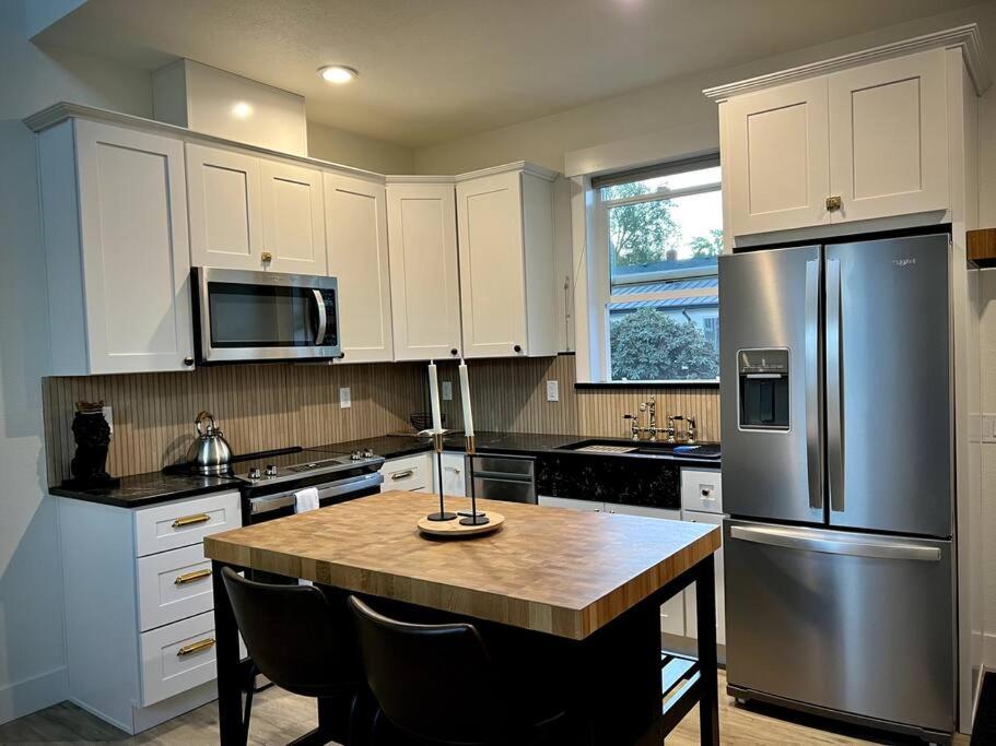 a kitchen with a refrigerator and a table with chairs at Brand New Custom Built Cottage in Downtown w/Pool! in Salem