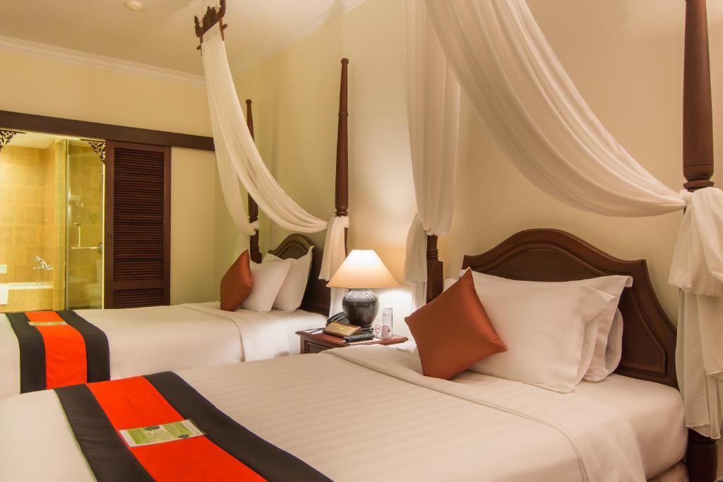 Postel nebo postele na pokoji v ubytování Angkor Palace Resort & Spa