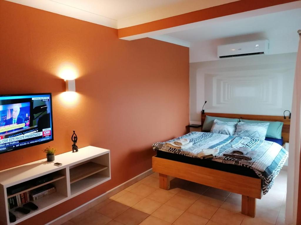 a bedroom with a bed and a flat screen tv at Apartamento Nora in Lagos