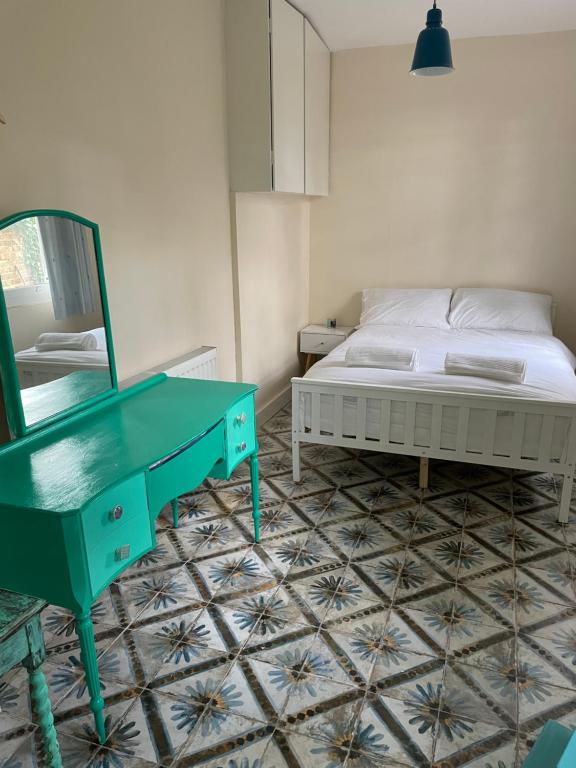 Schlafzimmer mit einem Bett, einem Spiegel und einem Tisch in der Unterkunft Fieldside Studio Flat in Hendon