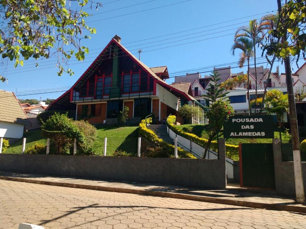 a house with a sign in front of it at Pousada das Alamedas in São Lourenço