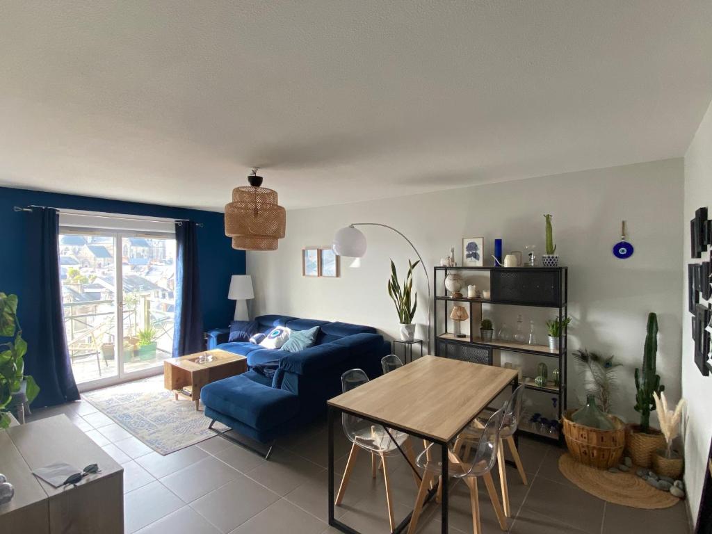 a living room with a blue couch and a table at Appartement pour les 24 heures in Le Mans