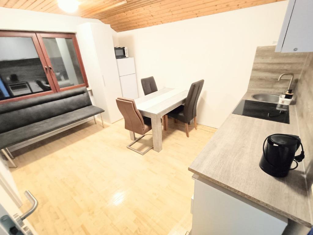 een keuken en een woonkamer met een tafel en stoelen bij FMI21Company Accommodation in Hochheim am Main
