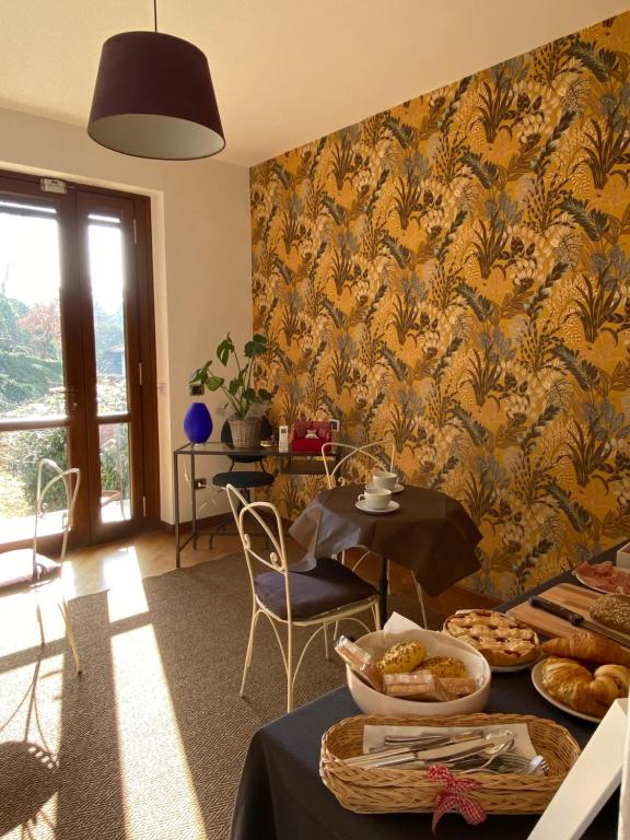 uma sala de jantar com uma mesa e um papel de parede amarelo em Il cantuccio em Ivrea