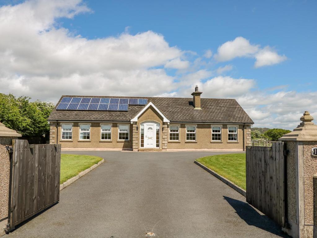 uma casa com painéis solares no telhado em Willow Tree Farm House em Newry
