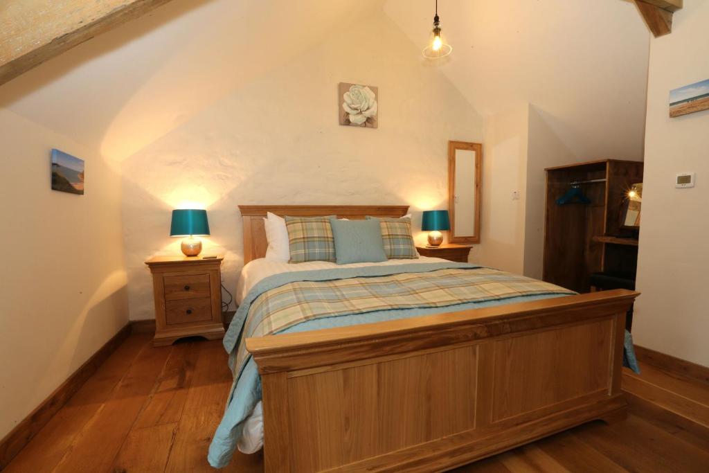a bedroom with a large bed in a attic at Snuggle hot tub Dolgoy in Blaencelyn