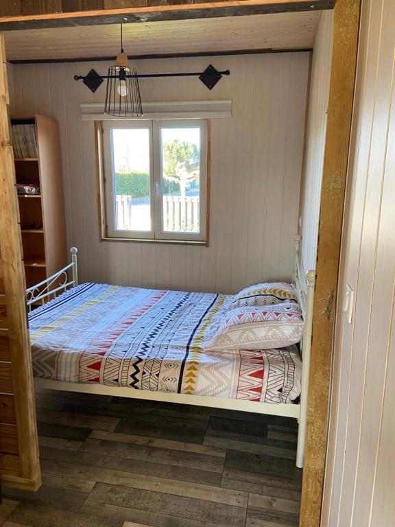 a bed in a room with a window at Gîte Lauraët in Linxe