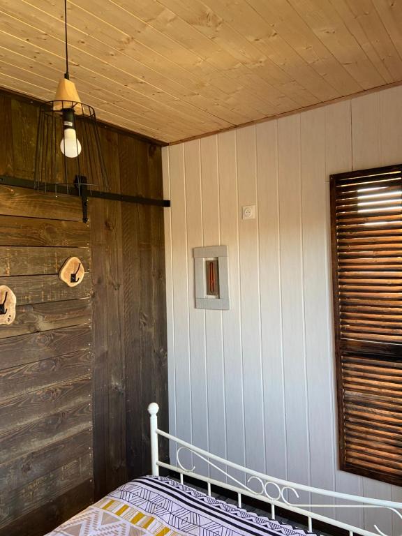 a bedroom with a bed and a wooden wall at Gîte Lauraët in Linxe