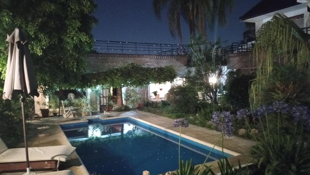una piscina frente a una casa por la noche en CABAÑAS VILLA CLUB 4 cerca del aeropuerto el palomar en Hurlingham