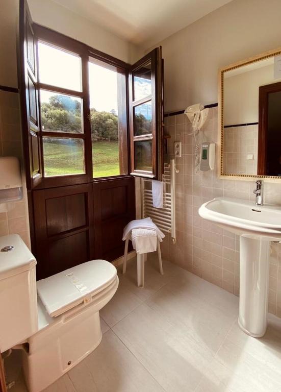 a bathroom with a sink and a toilet and a mirror at El Tejo de Comillas in Comillas