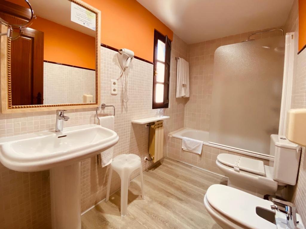 a bathroom with a sink and a toilet and a tub at El Tejo de Comillas in Comillas