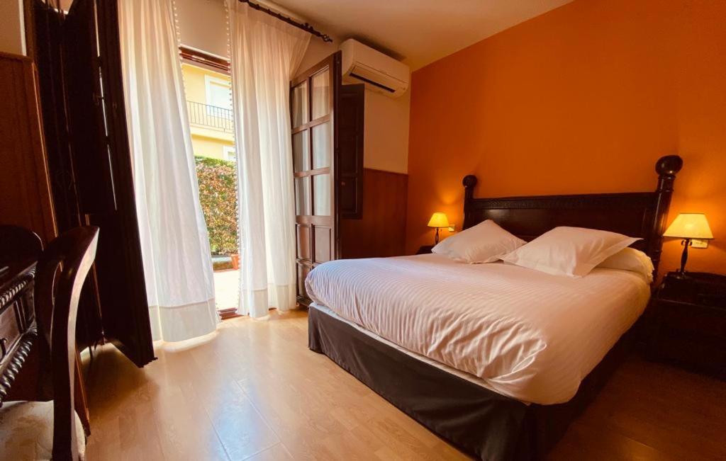 a bedroom with a bed and a large window at El Tejo de Comillas in Comillas
