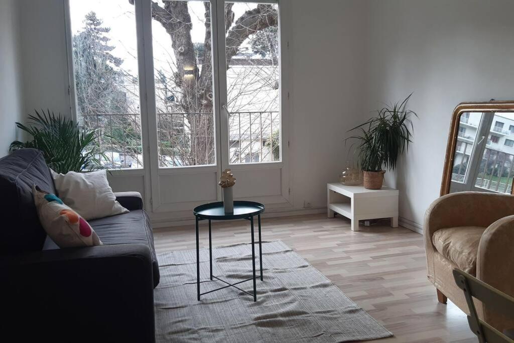 ein Wohnzimmer mit einem Sofa und einem Tisch in der Unterkunft Charmant Appartement 55 m 2 in Bougival