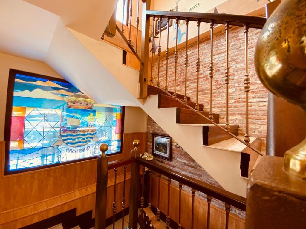 a staircase with a mural of a boat on the wall at El Tejo de Comillas in Comillas