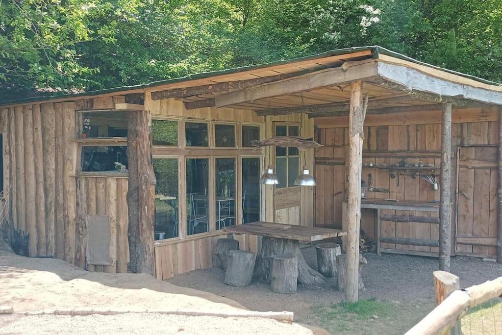 a wooden pavilion with a picnic table in front of it at Cabane aux papillons in Saint-Éloy-les-Tuileries