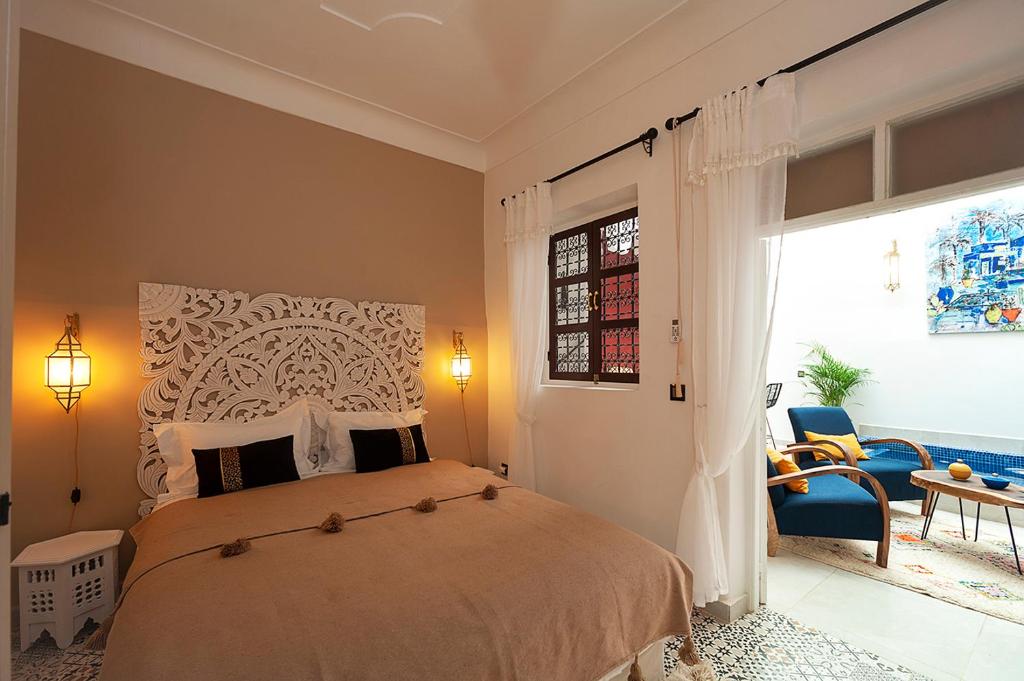 een slaapkamer met een bed en een groot raam bij RIAD JULILU PRIVATISE in Marrakesh