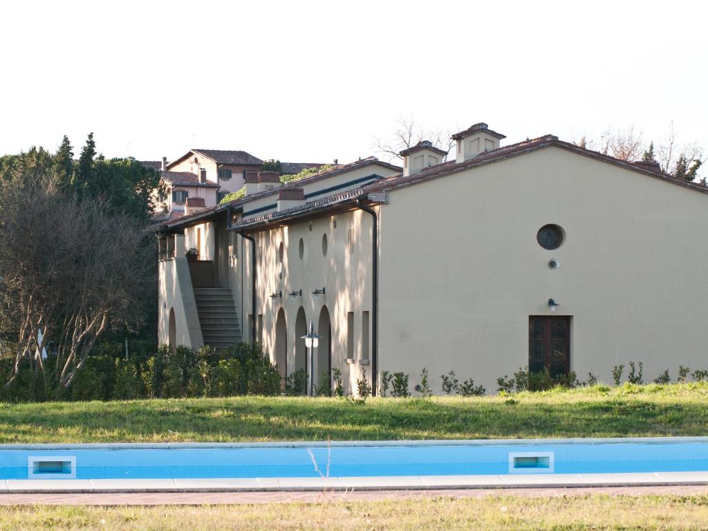 un edificio blanco con una piscina frente a él en San Ruffino Apartments, en Lari