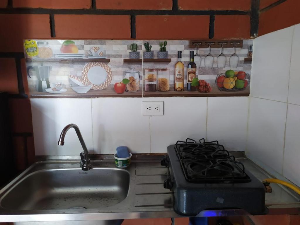 een keuken met een wastafel en een fornuis bij Cielito Lindo in Necoclí