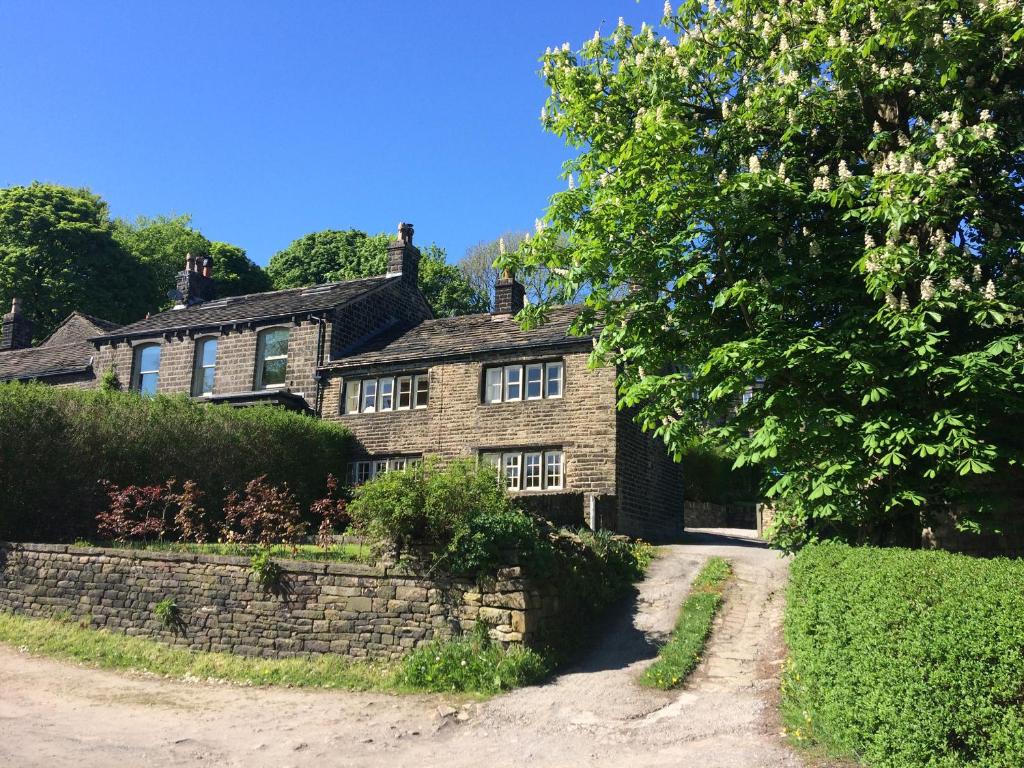 an old brick house with a stone wall at Hawkyard's Cottage in Oldham