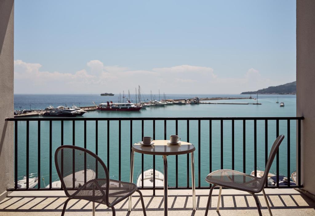 a table and chairs on a balcony with a harbor at Strada Marina Hotel in Zakynthos