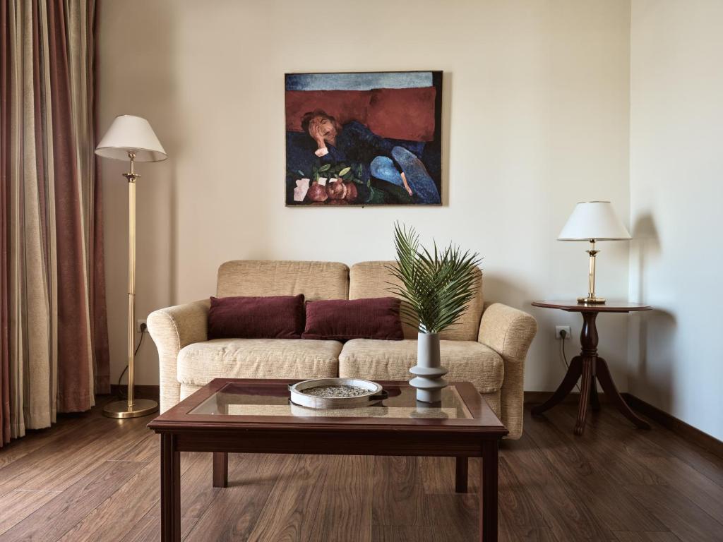 a living room with a couch and a painting on the wall at Strada Marina Hotel in Zakynthos